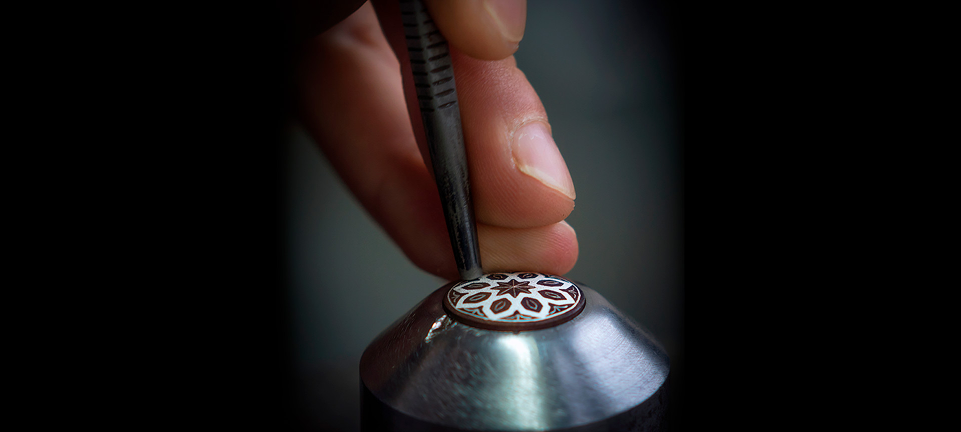 Craftsman decorating a piece using the damascene technique