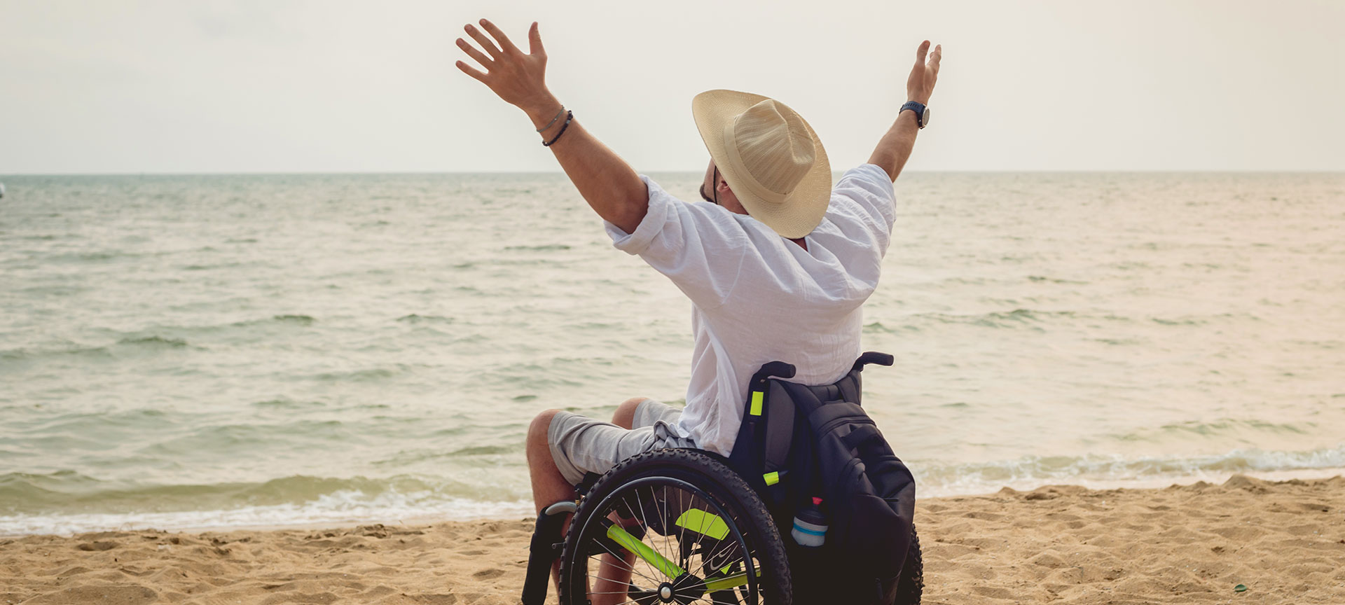 Person with disability in a wheelchair on the beach Person with disability in a wheelchair on the beach