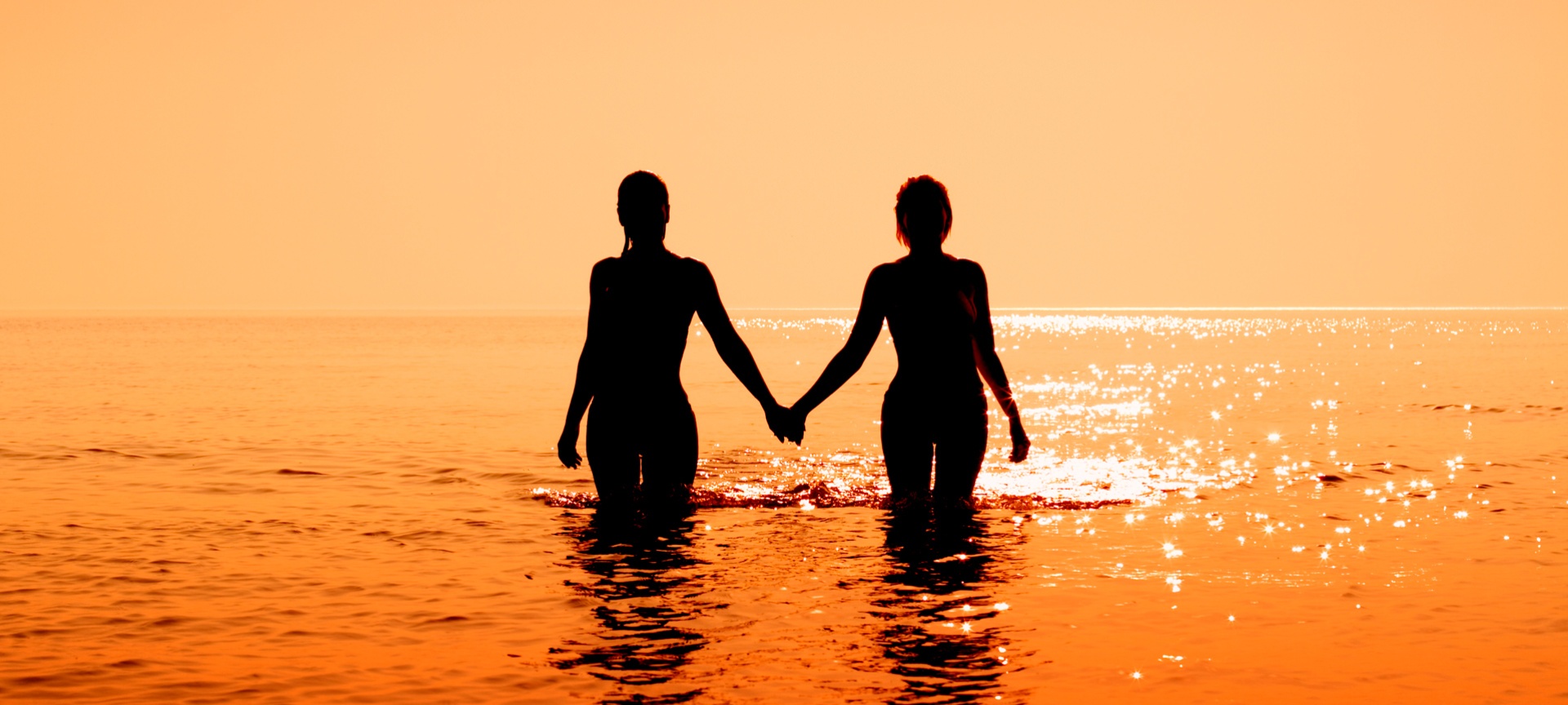 Paar im Meer bei Sonnenuntergang