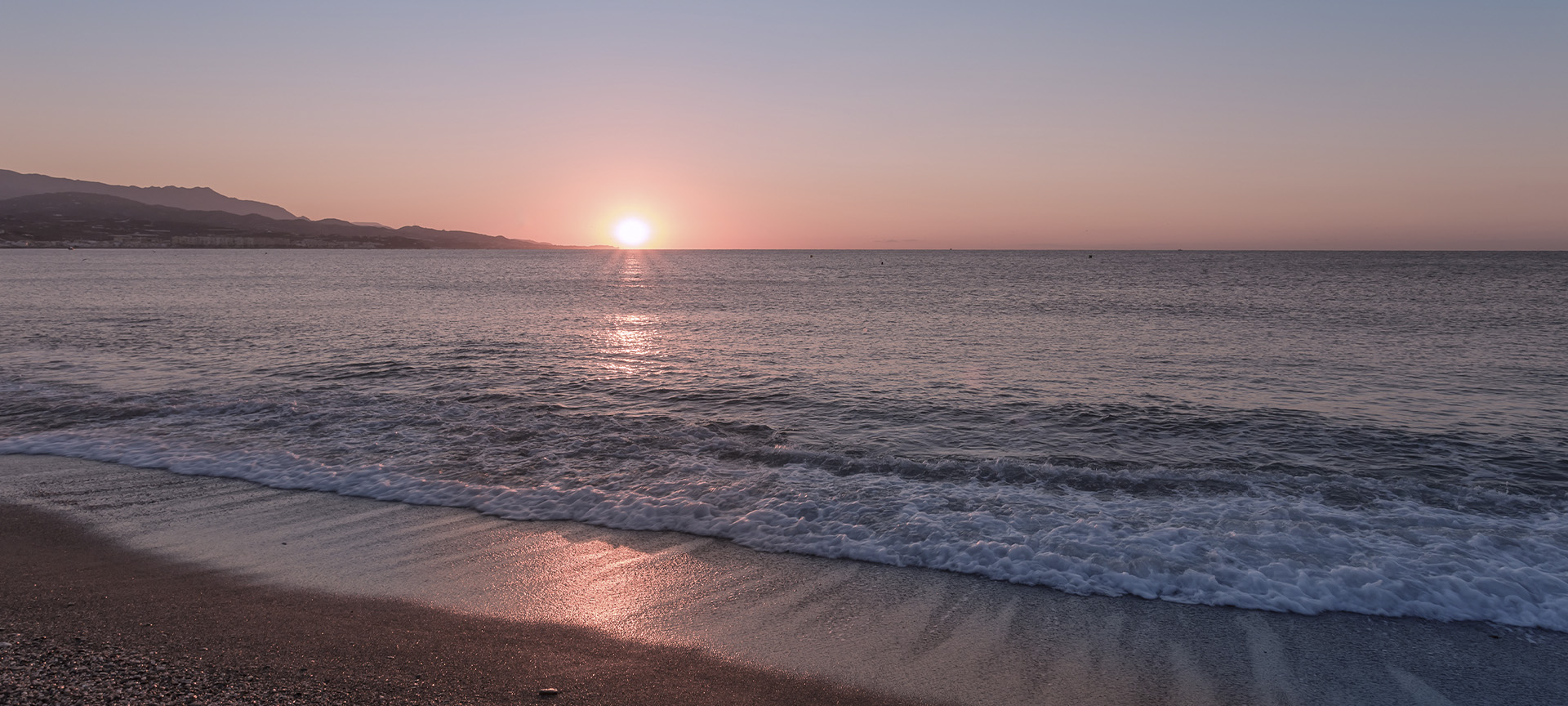 Zachód słońca na plaży w Torre del Mar (prowincja Malaga, Andaluzja)