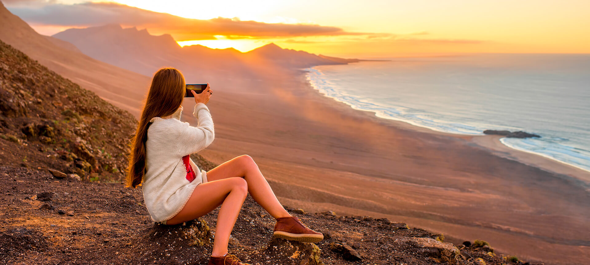 Girl taking photos on the beach of Cofete, Fuerteventura