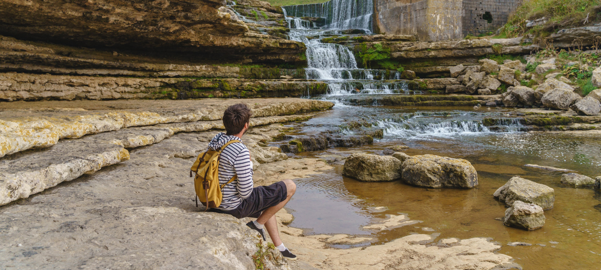 Tourist betrachtet den Bolao-Wasserfall in Toñanes, Kantabrien