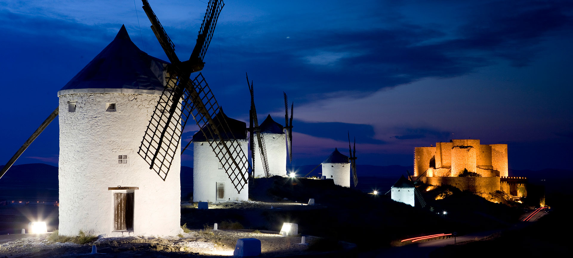 View of the windmills at night, with Consuegra Castle in the background. Toledo