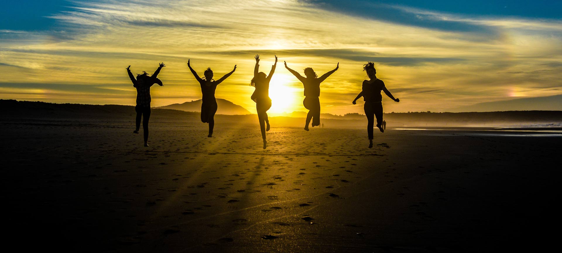 Freunde bei Sonnenuntergang an einem Strand in Galicien