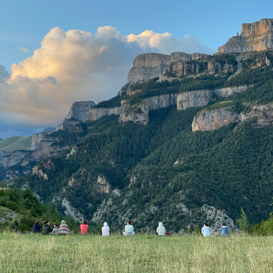 Partecipanti al ritiro mentre meditano di fronte a Sestrales de Vió a Huesca, Aragona