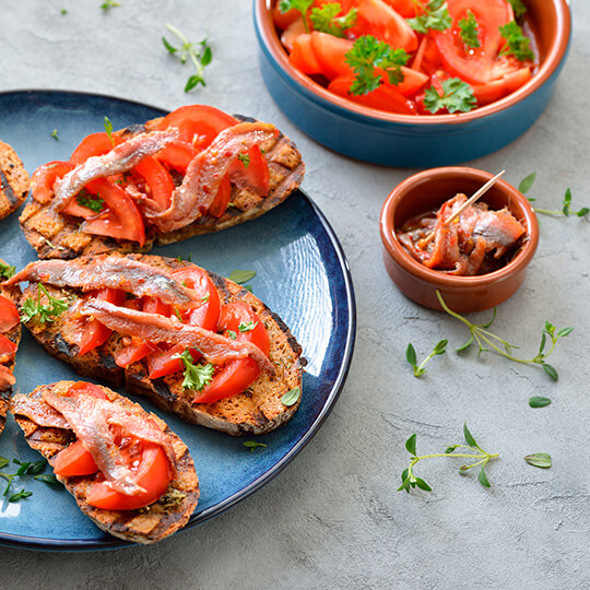 Acciughe di Santoña sul pane con pomodoro e olio d'oliva