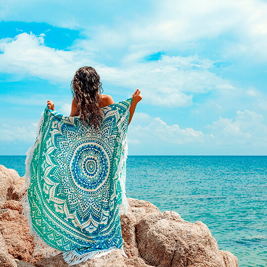 Giovane hippie sulla spiaggia con un pareo
