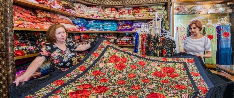 Eine Frau beim Kauf eines Manilatuches in einem Laden in Sevilla Eine Frau beim Kauf eines Manilatuches in einem Laden in Sevilla
