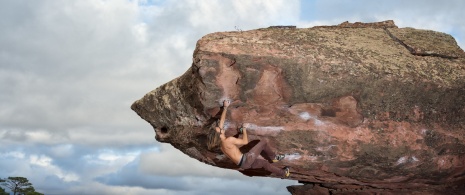 Mann klettert auf einen Felsblock in der Sierra de Albarracín in Teruel, Aragón, Spanien. Mann klettert auf einen Felsblock in der Sierra de Albarracín in Teruel, Aragón, Spanien.