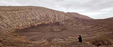 Tourist looking at the Caldera Blanca volcano in Lanzarote, Canary Islands Tourist looking at the Caldera Blanca volcano in Lanzarote, Canary Islands