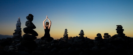 Woman doing yoga at sunset on Duque de Adeje beach in Tenerife, Canary Islands Woman doing yoga at sunset on Duque de Adeje beach in Tenerife, Canary Islands