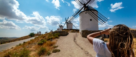 Girl taking a photo of the windmills in Consuegra, Toledo Girl taking a photo of the windmills in Consuegra, Toledo