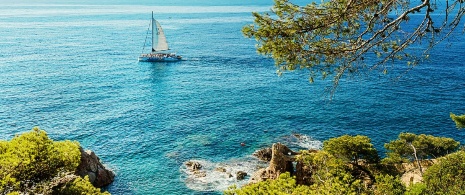 Sailboat sailing on the coast of Lloret de Mar in Girona, Catalonia Sailboat sailing on the coast of Lloret de Mar in Girona, Catalonia