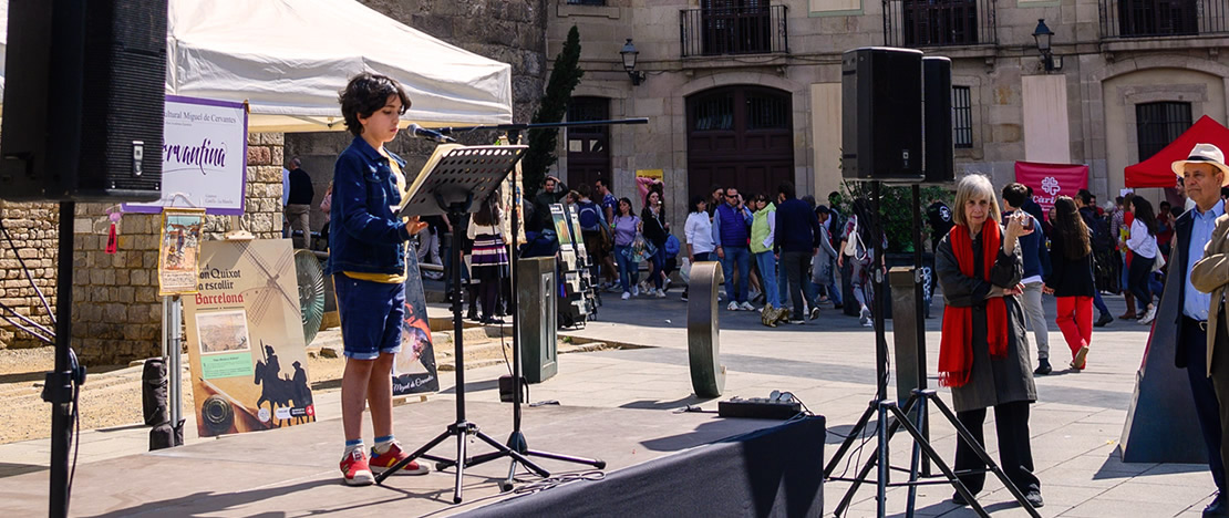 Child reading Don Quixote in front of the Barcelona Cathedral during Sant Jordi Child reading Don Quixote in front of the Barcelona Cathedral during Sant Jordi