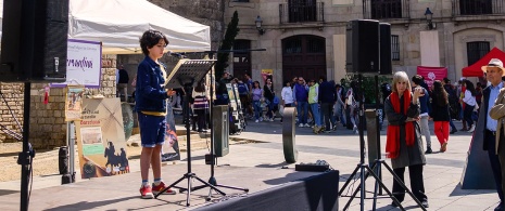 Child reading Don Quixote in front of the Barcelona Cathedral during Sant Jordi Child reading Don Quixote in front of the Barcelona Cathedral during Sant Jordi