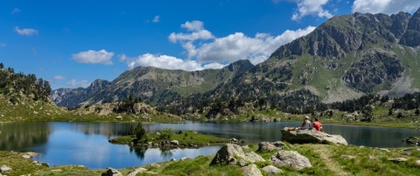 Des randonneurs se reposant au bord du lac de Colomers dans le parc national d'Aigüestortes i Estany de Sant Maurici, Lérida, Catalogne Des randonneurs se reposant au bord du lac de Colomers dans le parc national d'Aigüestortes i Estany de Sant Maurici, Lérida, Catalogne