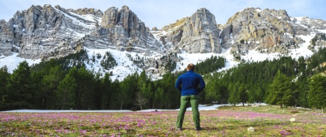Turista observando as belas montanhas cobertas de neve na primavera, Prat de Cadi, Catalunha Turista observando as belas montanhas cobertas de neve na primavera, Prat de Cadi, Catalunha