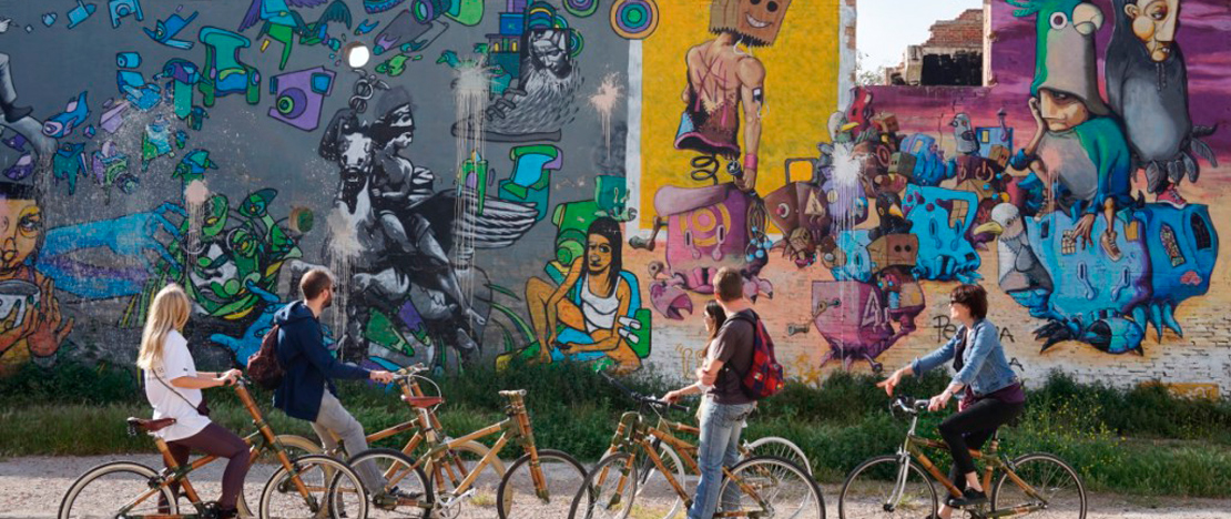 Tourists on an eco-bike street art tour of Barcelona, Catalonia
