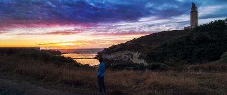 Girl contemplating the sunset near the Tower of Hercules, Galicia Girl contemplating the sunset near the Tower of Hercules, Galicia