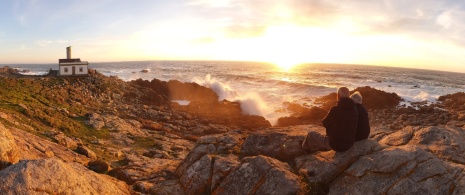 Tourists watching the sunset at the Corrubedo lighthouse in A Coruna, Galicia Tourists watching the sunset at the Corrubedo lighthouse in A Coruna, Galicia