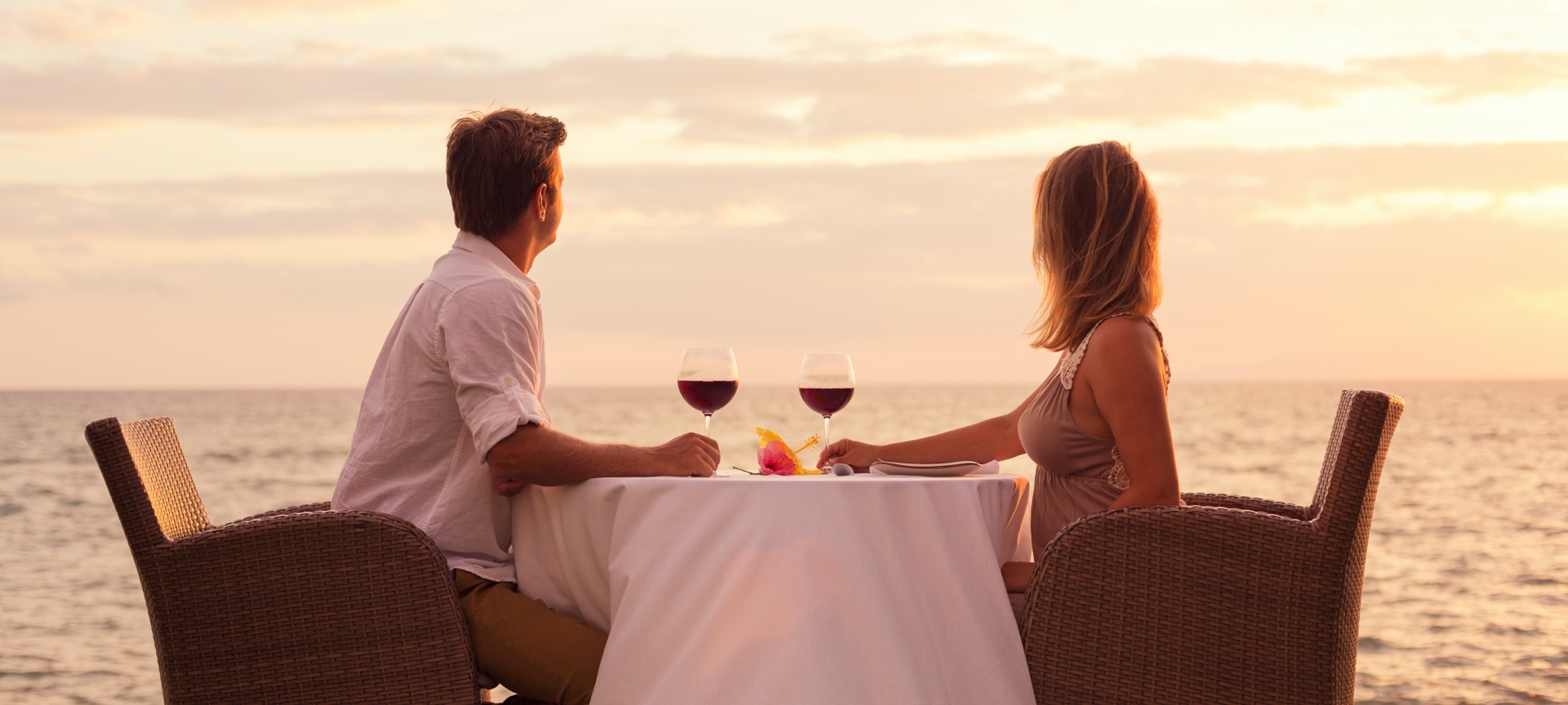 Couple enjoying a glass of wine by the sea