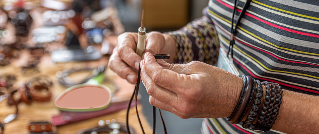 Craftsman making leather bracelets Craftsman making leather bracelets