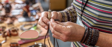 Craftsman making leather bracelets Craftsman making leather bracelets