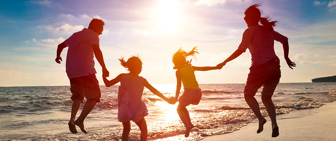 Familie bei Sonnenuntergang am Strand
