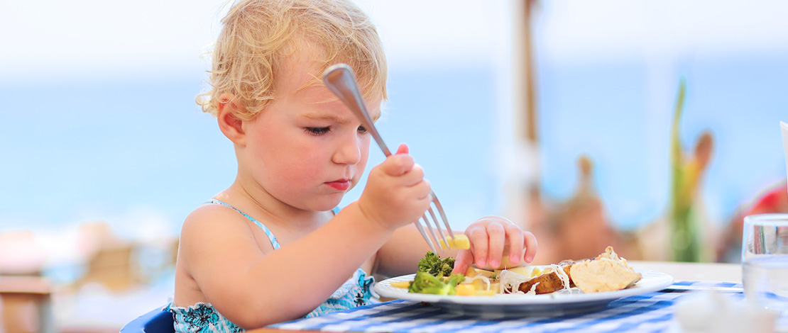 休暇中に海辺のレストランで食事をする幼い女の子 休暇中に海辺のレストランで食事をする幼い女の子