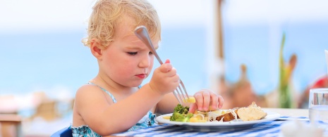休暇中に海辺のレストランで食事をする幼い女の子 休暇中に海辺のレストランで食事をする幼い女の子