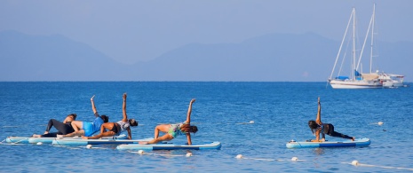 A group of people doing yoga on a SUP board. A group of people doing yoga on a SUP board.