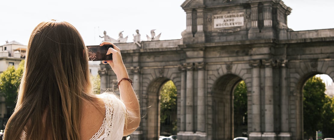 Turista fotografando a Porta de Alcalá em Madri, Comunidade de Madri