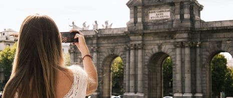 Turista fotografando a Porta de Alcalá em Madri, Comunidade de Madri Turista fotografando a Porta de Alcalá em Madri, Comunidade de Madri