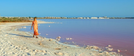 Tourist looking at the pink lagoon of La Mata y Torrevieja in Alicante, region of Valencia Tourist looking at the pink lagoon of La Mata y Torrevieja in Alicante, region of Valencia