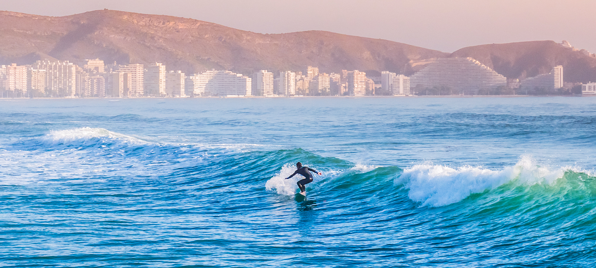 Surfer practising on the Cullera beach in Valencia
