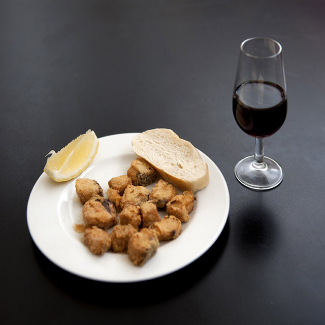 Tapa mit mariniertem Fisch und Glas Wein