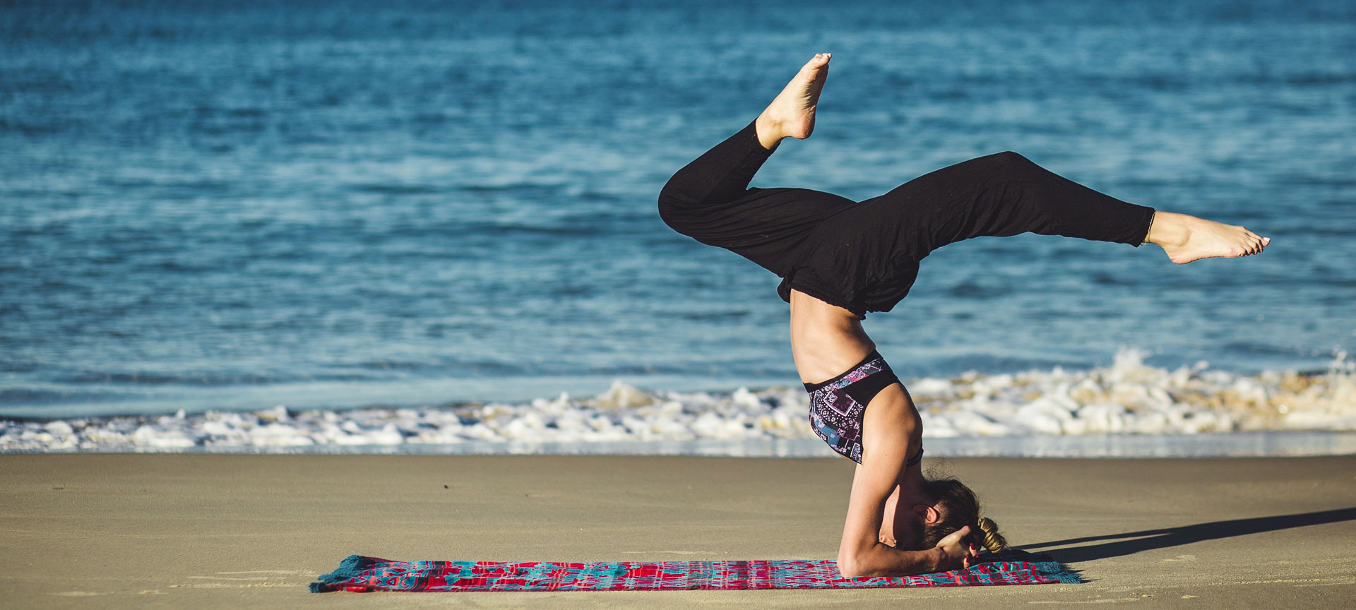 Girl practising yoga on the beach